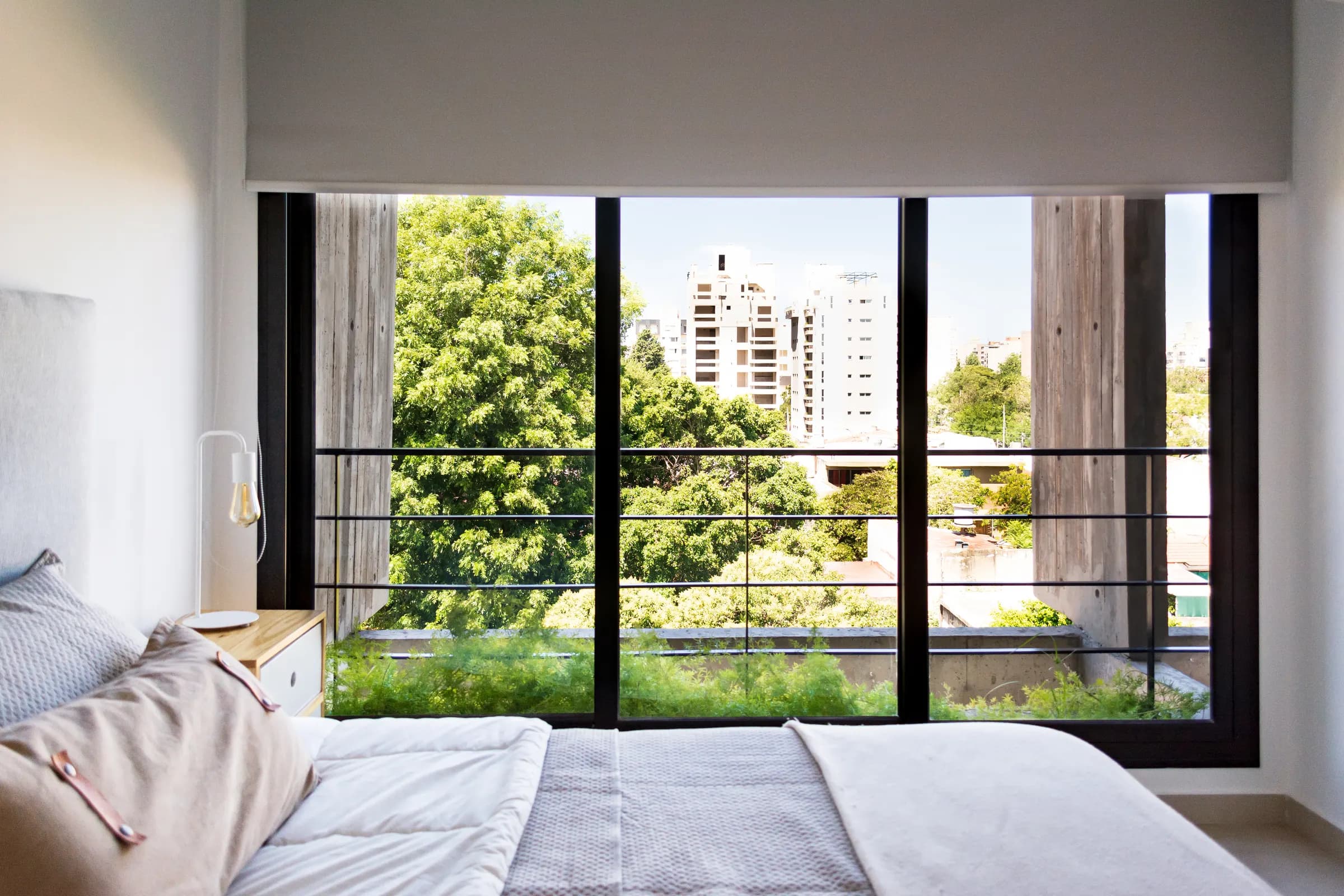 Dormitorio de Casullo con ventanal y vista a los árboles de Morón